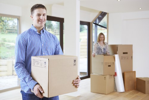 Movers carefully loading sofas and tables into a moving truck