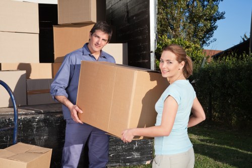 Piano movers using protective padding and equipment during loading